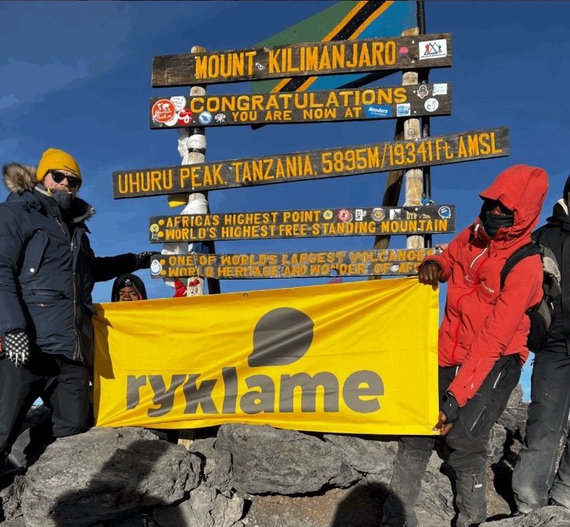 Tom Egill heiser Ryklame-flagget på toppen av Kilimanjaro.